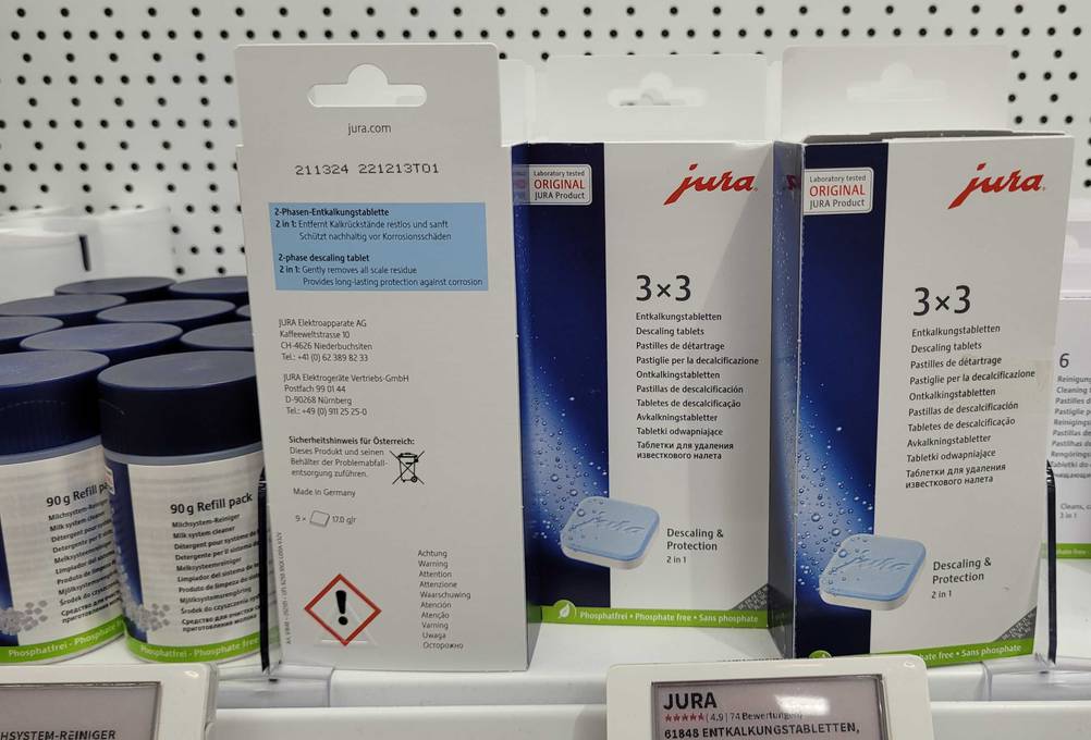 Entkalkungstabletten-Kaffeevollautomat-Test: mehrere Verpackungen von Entkalkungstabletten mit 9 Stück Inhalt, mit der Vorderseite und Rückseite ersichtlich.