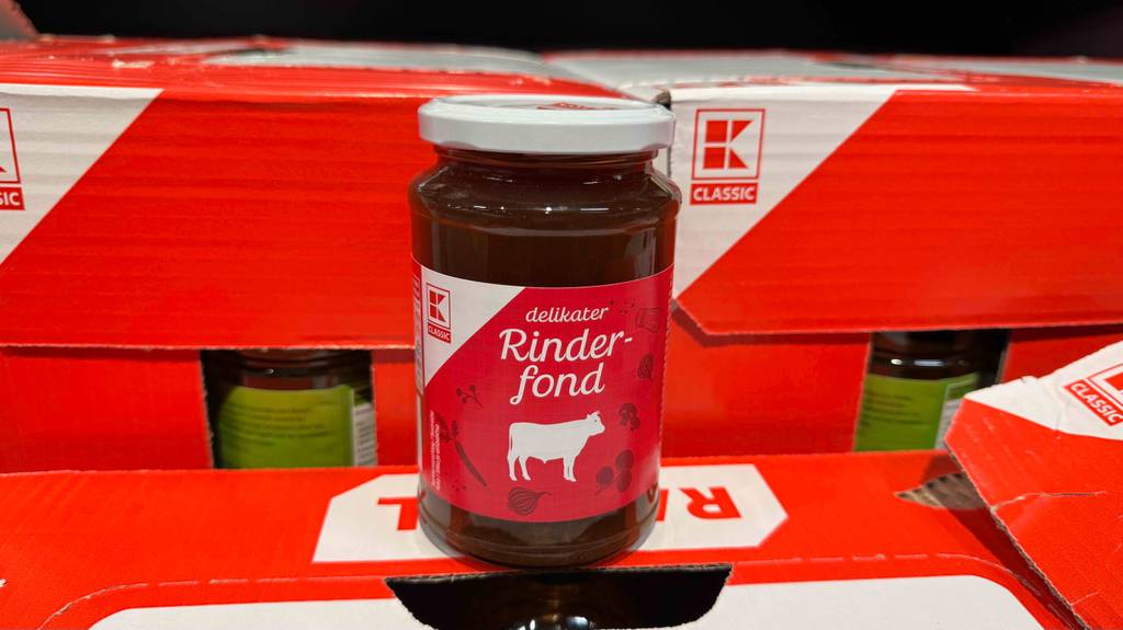 Ein getestetes Glas Rinderfond steht auf Kartons.