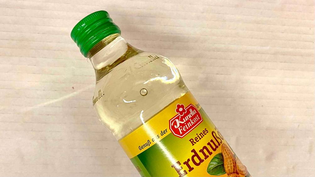 Erdnussöl im Test: Flasche liegt auf hellem Untergrund