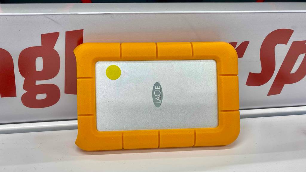 Externe 4-TB-Festplatte-Test: eine Festplatte mit orangefarbenem Rand ist an einem Regal angelehnt.