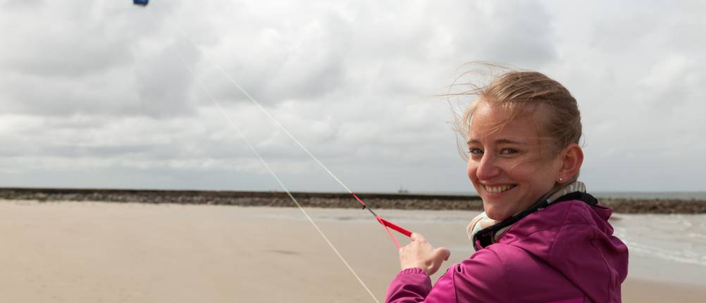 2-Leiner-Lenkmatten-Test: Frau hält am Strand eine 2-Leiner-Lenkmatte in der Hand.