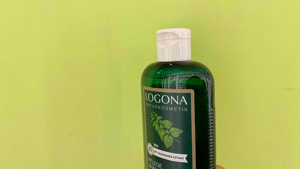Brennessel-Shampoo im Test: Oberer Teil der Flasche in Nahaufnahme vor grünem Hintergrund