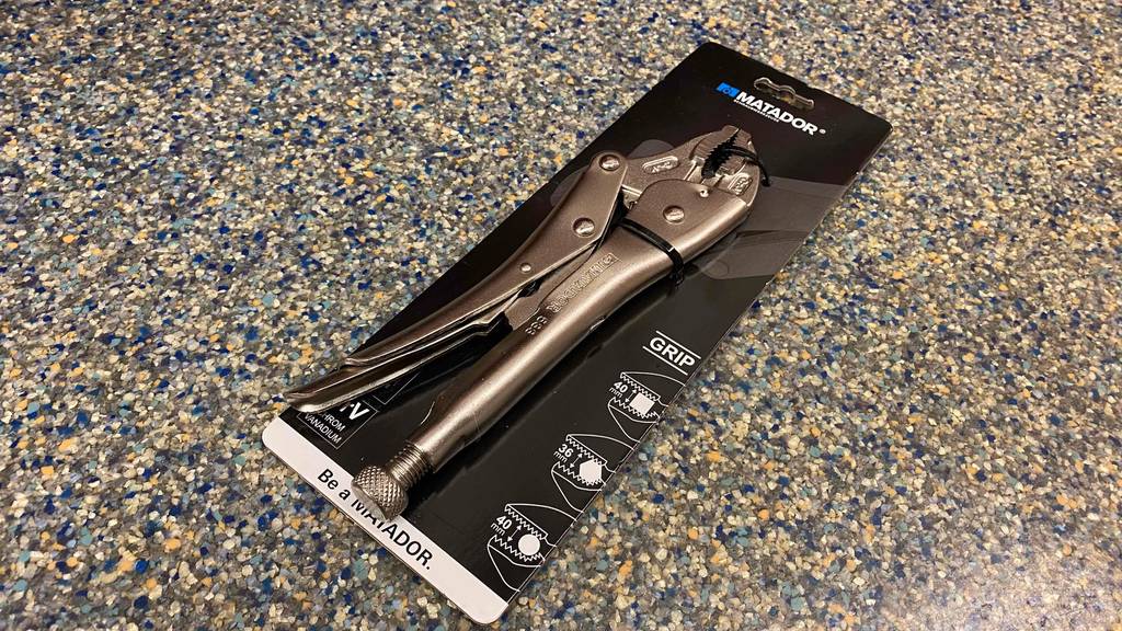 Die getestete Gripzange in ihrer Originalverpackung quer auf einer bunten Unterlage