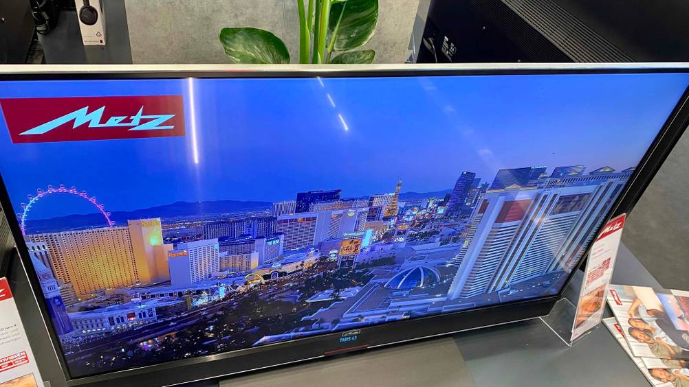 Ein 43-Zoll-Fernseher angeschaltet auf grauem Untergrund.