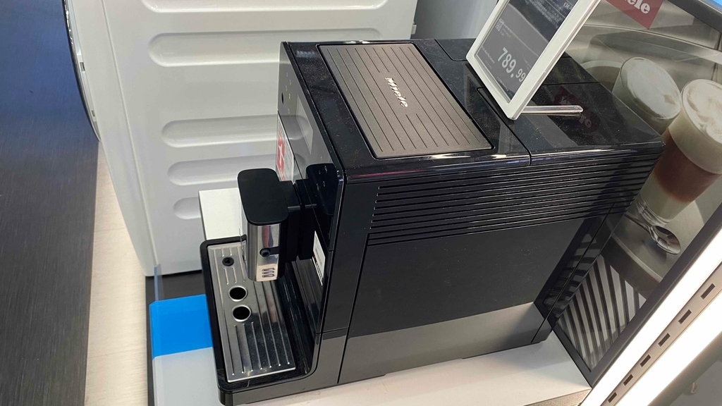 Schwarzer Kaffeevollautomat von der Seite mit Preisschild im Test.