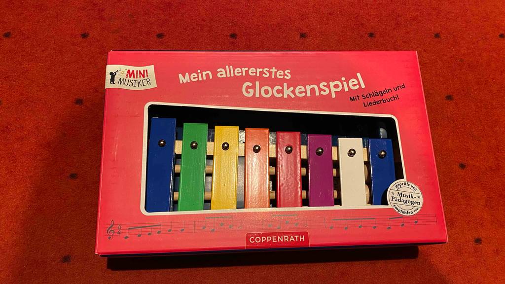 Xylophon getestet: Ein verpacktes Xylophon liegt auf einer roten Fläche.