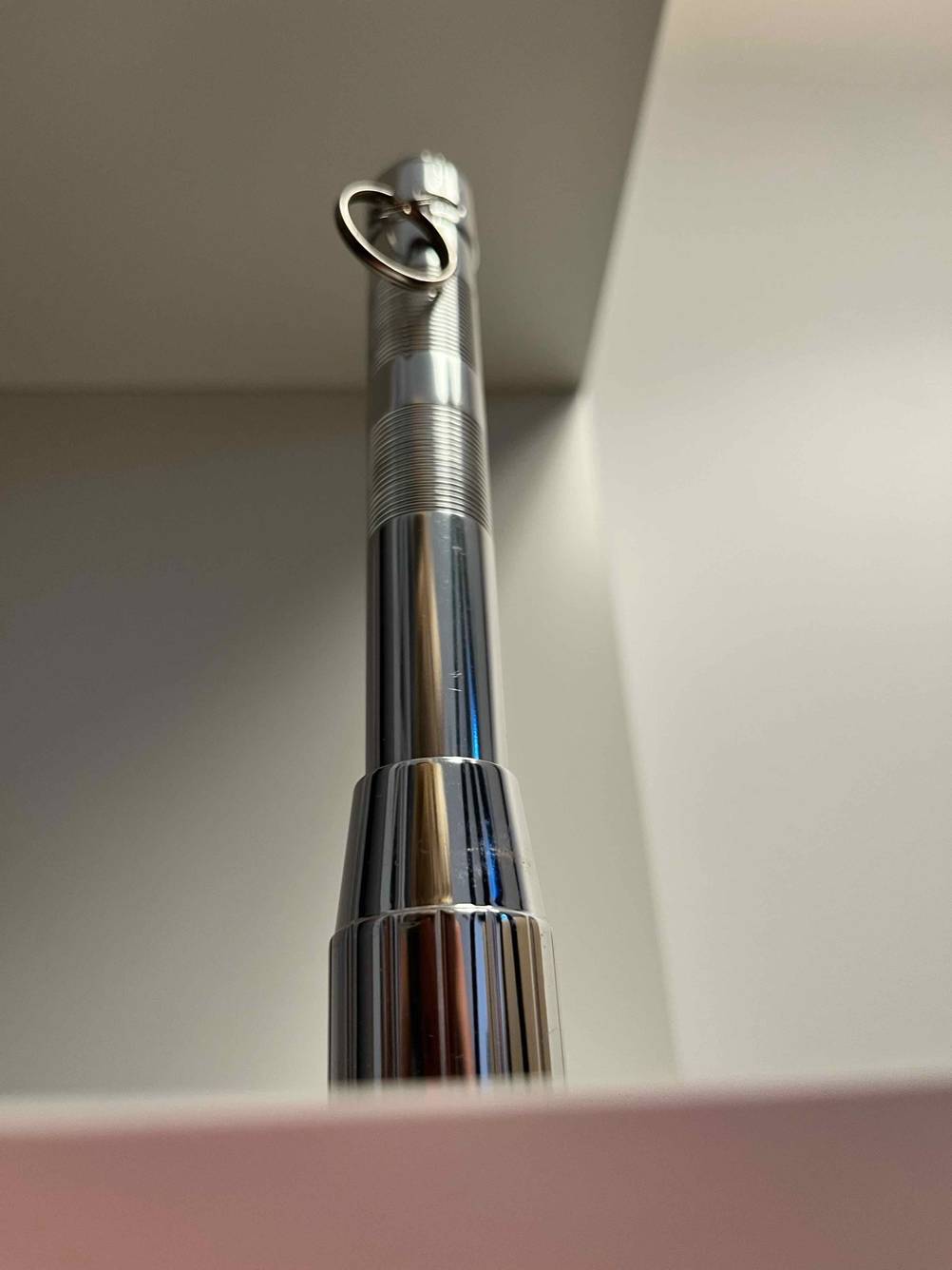 Eine getestete Mini-Taschenlampe auf der Seite der Lampe stehend in einem Regal.