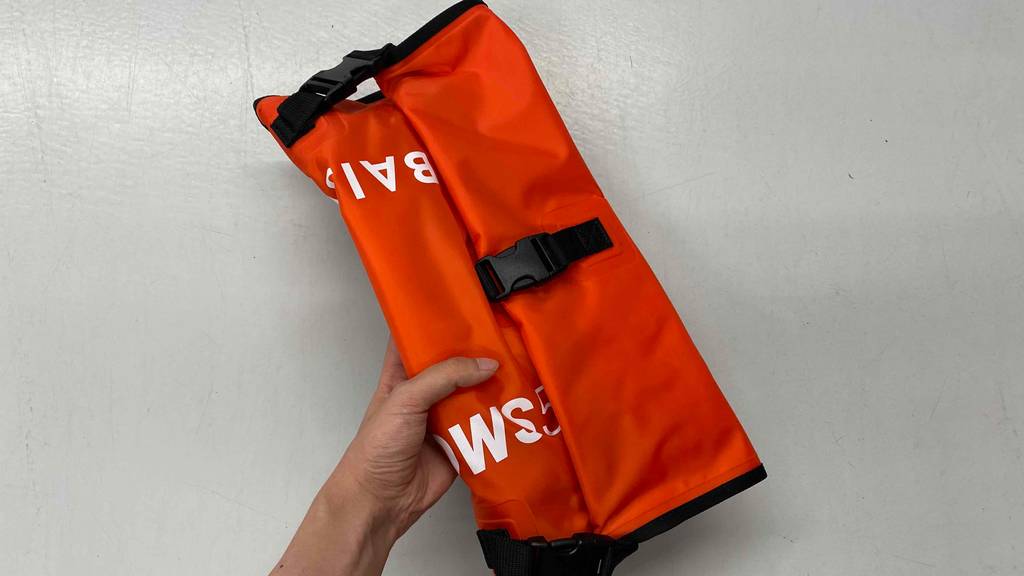 Schwimmboje getestet: orangefarbige zusammengefaltete Schwimmboje mit Schnallen.