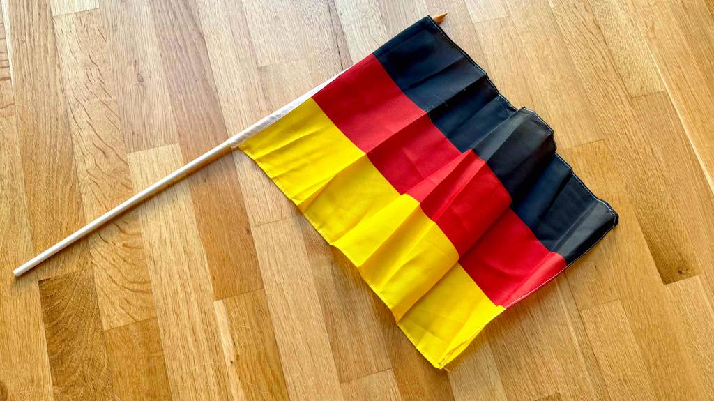 Deutschlandfahne-Test: eine ausgebreitete Deutschlandfahne liegt auf einem Holzboden.