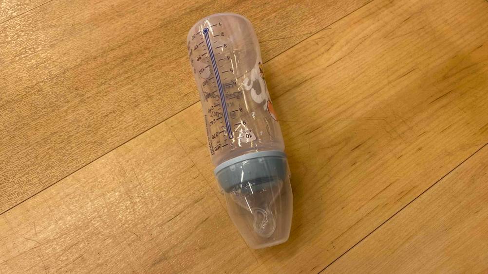 Babyflaschen getestet: eine Babyflasche liegend auf einem Boden mit Messskala darauf ersichtlich.