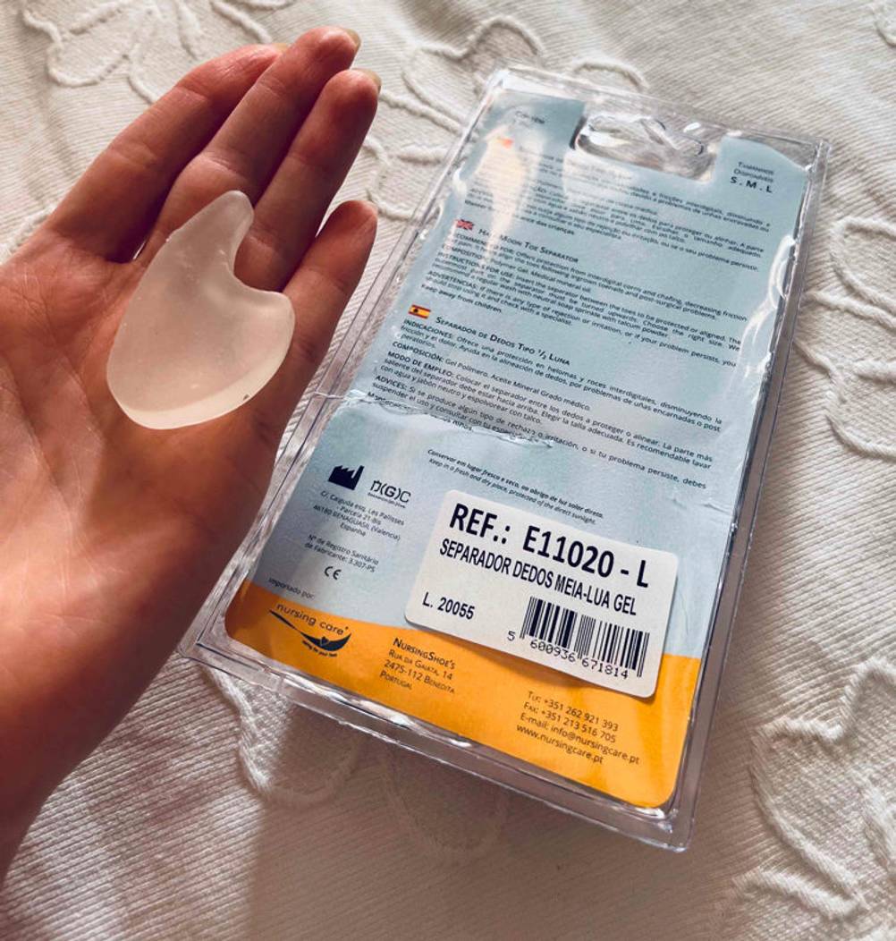 Zehenspreizer im Test: ausgepackter Zehenspreizer wird in der Hand neben Verpackung gehalten.