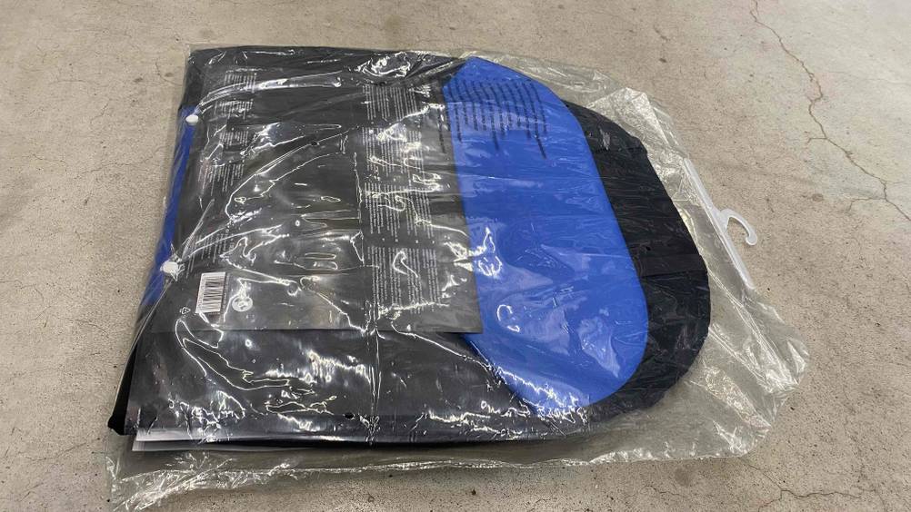 Autositzauflage getestet: Ein Packung von hinten auf einer hellen Oberfläche liegend.