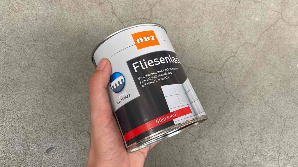 Fliesenlack-Test: Fliesenlack in der Hand mit Hinweis auf haftstarke Eigenschaft.