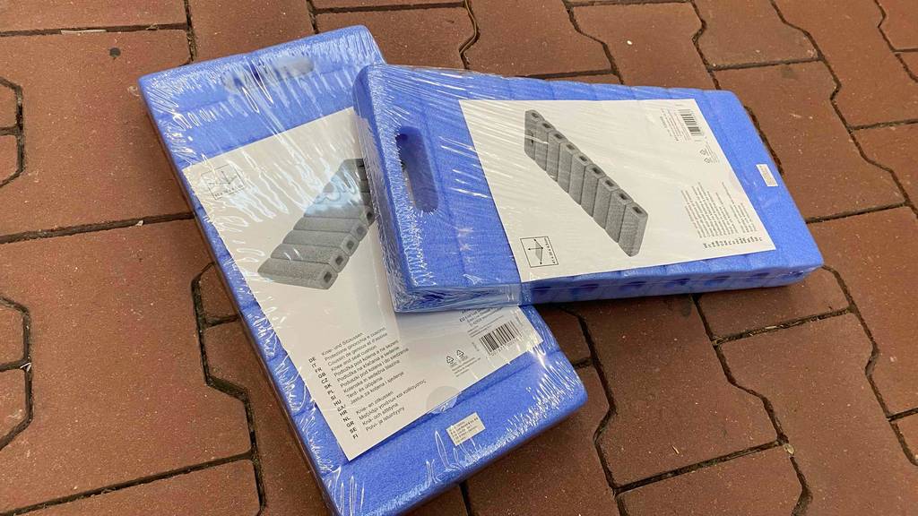 Kniekissen (Garten) getestet: Zwei verpackte Kniekissen leicht übereinander auf einer Steinfläche.