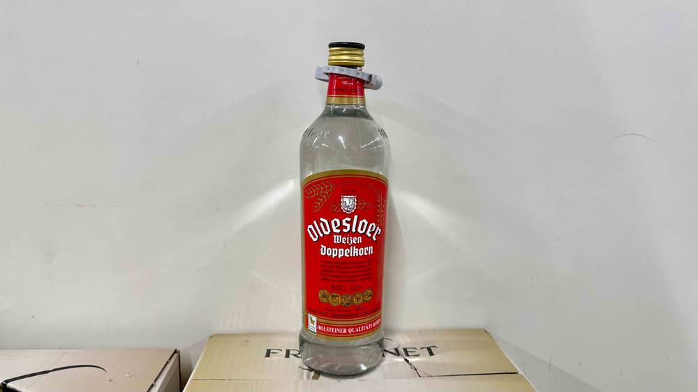 Eine Flasche des getesteten Doppelkorns steht auf einem Karton vor einer weißen Wand.
