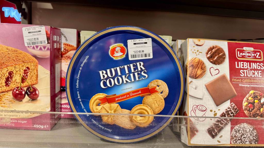 Eine Dose getestete dänische Kekse steht neben anderen Keksen in einem Regal.