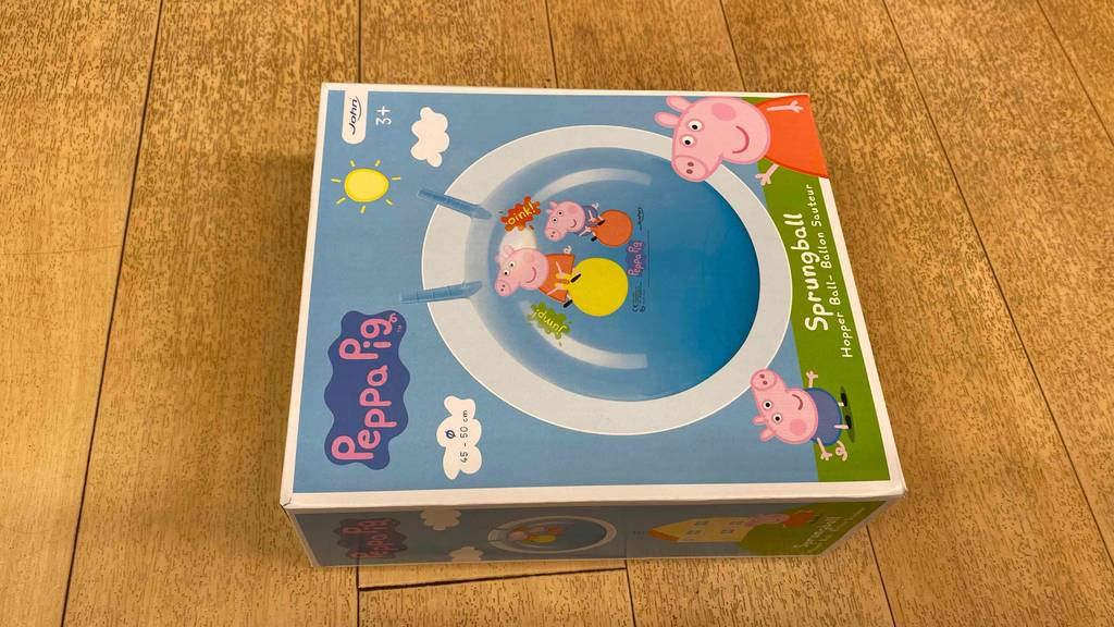 Hüpfball getestet: Ein verpackter Ball liegt horizontal auf einem Holzboden.