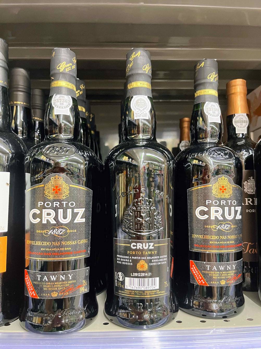 Portwein im Test: Mehrere Flaschen Portwein in einem Regal eine Flasche ist umgedreht