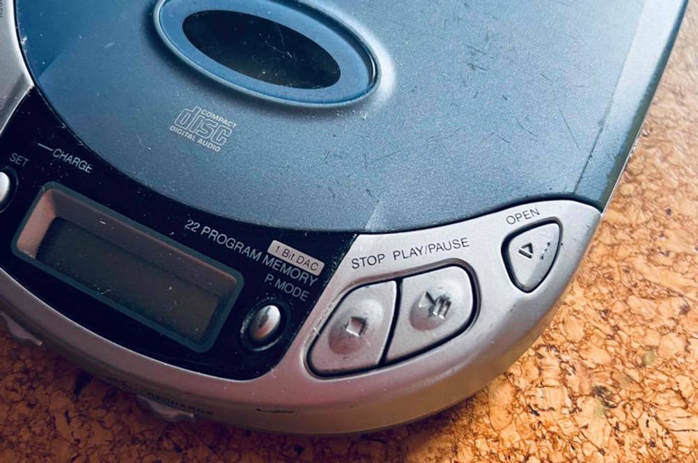 Im Test: Ein Tragbarer CD-Player auf einem Holzboden, Bedienelemente und Display.