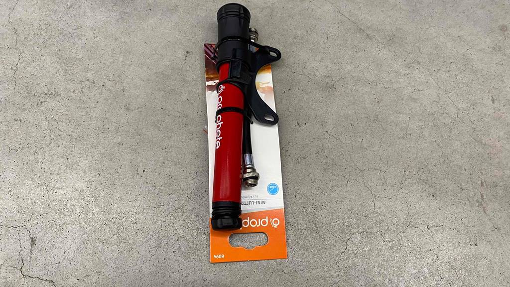 Minipumpe getestet: Minipumpe in der Farbe rot-schwarz liegt auf einem Boden in der Verpackung.