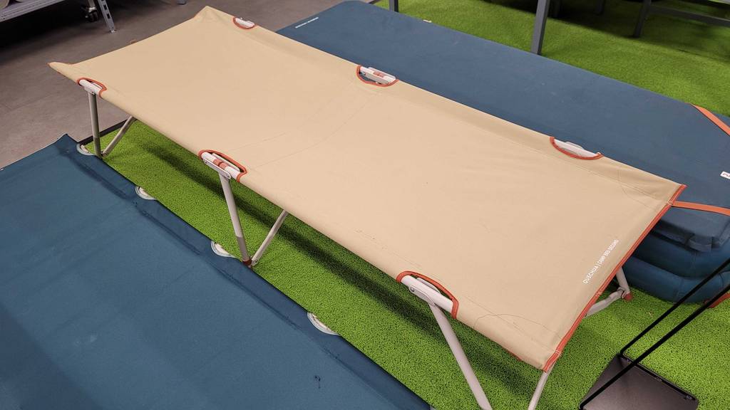 Ein getestetes Feldbett steht in einem Geschäft neben anderen Modellen.