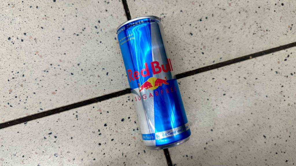 Eine Dose getesteter Red-Bull-Energy-Drink liegt auf einem Boden.