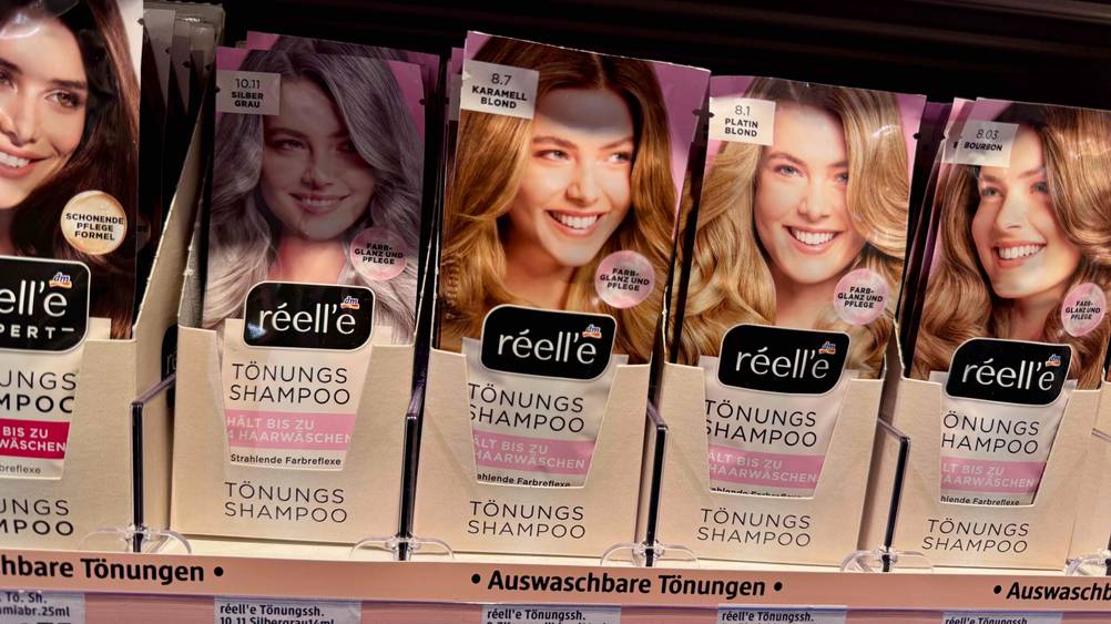 Mehrere getestete Tönungsshampoos in verschiedenen Nuancen sind in einem Regal platziert.