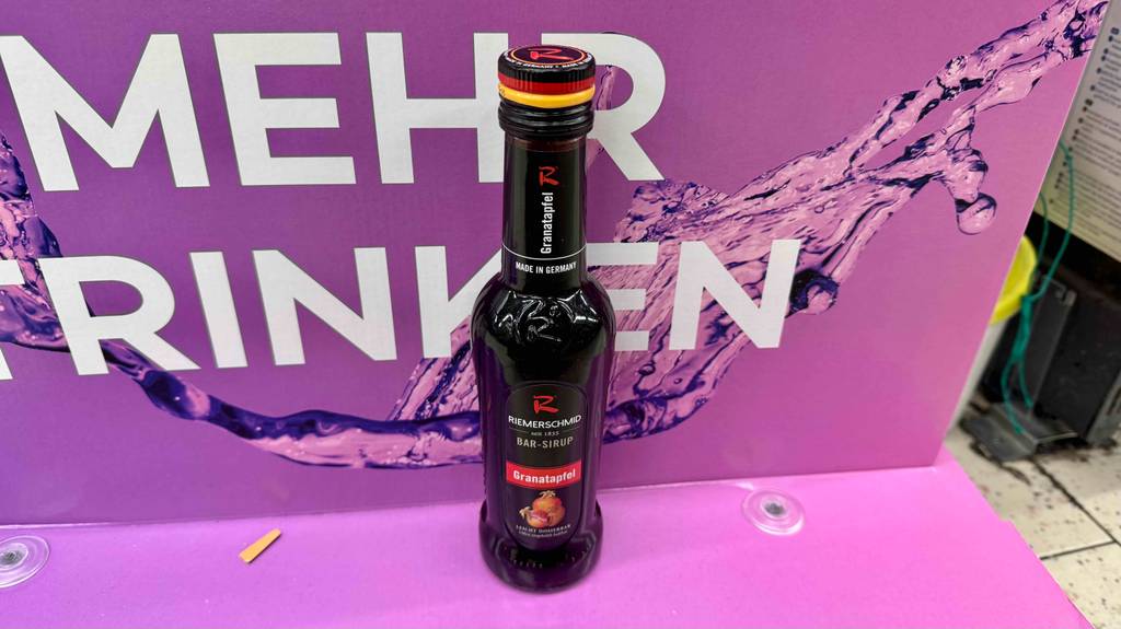 Ein getesteter Granatapfelsirup steht auf einem Aufsteller.