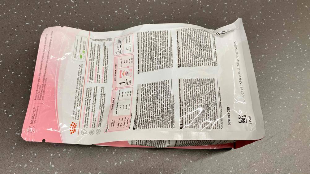 Rückseite einer Verpackung des getesteten Kitten-Trockenfutters auf einer grauen Fläche.