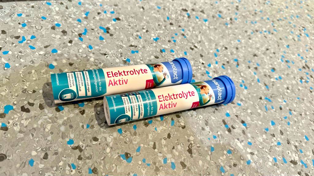Zwei Packungen getestete Elektrolyte-Tabletten, mit 20 Brausetabletten darin, liegen auf einem Boden.