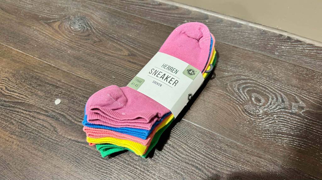 Bunte-Socken liegen auf einem Boden, mit Sicht auf den Bund.