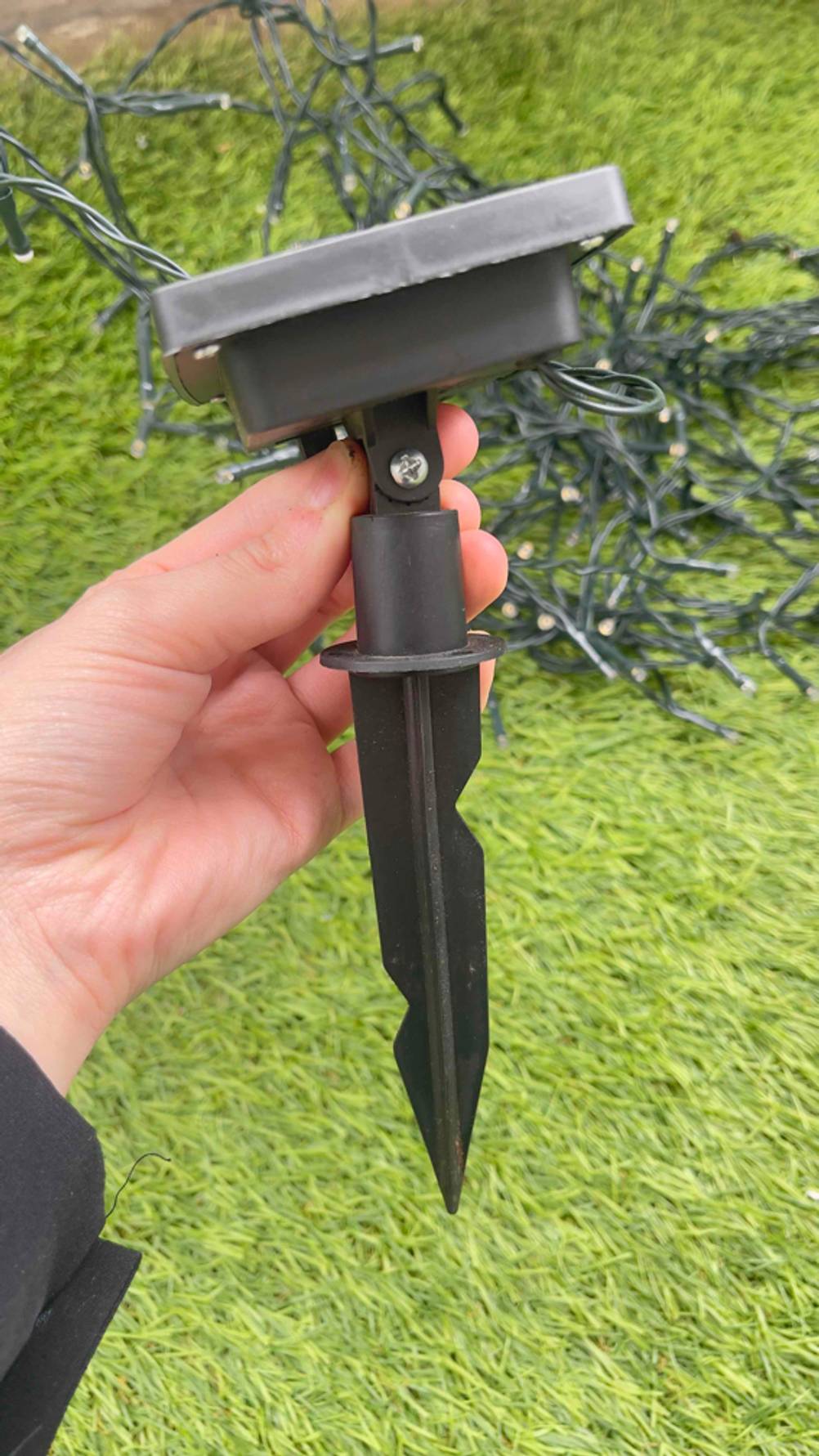 Der Erdspieß der getesteten Solar-Lichterkette wird in der Hand gehalten.
