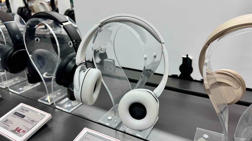 Der weiße getestete Sony-Over-Ear-Kopfhörer hängt ausgestellt neben weiteren Kopfhörern im Verkaufsbereich.