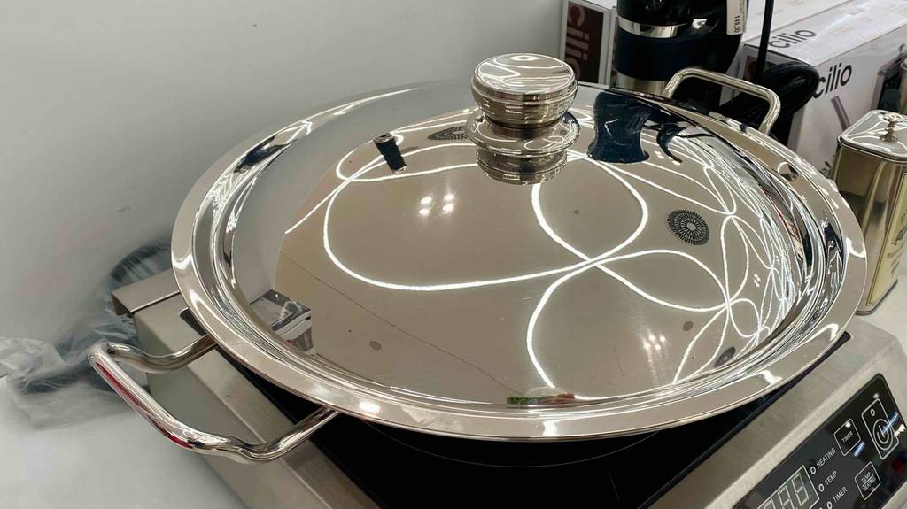 Elektro-Wok im Test: Deckel mit Griff eines Elektro-Woks im Fokus.