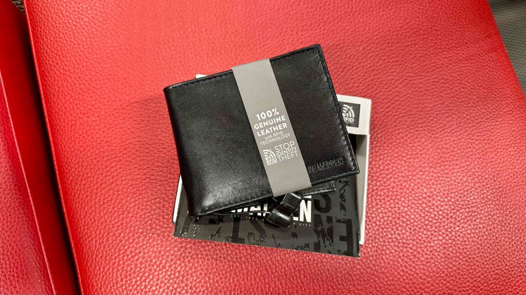Eine schwarze getestete Herren-Geldbörse liegt auf der Verpackung.