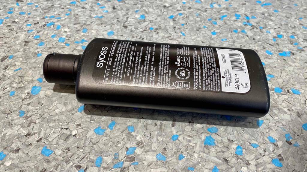 Keratin-Shampoo-Test: Syoss Shampoo liegend auf einer marmorierten Fläche - Rückseite ersichtlich.