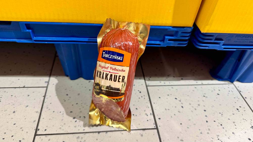 Die getestete Krakauer Wurst, die in einem Stück eingeschweißt ist, lehnt an einer Palette.