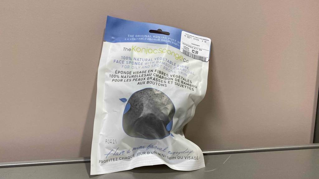 Konjac-Schwamm-Test: ein schwarzer Konjac-Schwamm in der Verpackung ist an einer Wand angelehnt.