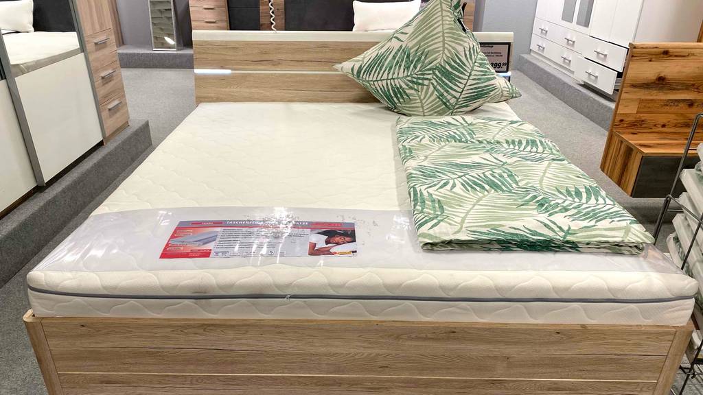 Matratze-180x200 im Test: ein Bett mit Matratze darauf, welches in einem Geschäft ausgestellt ist.