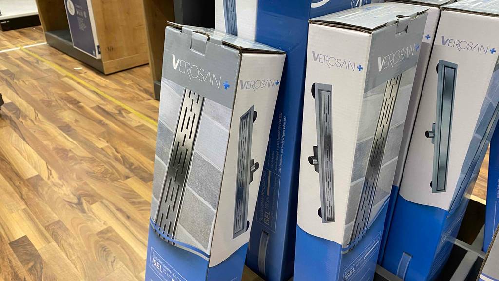 Duschrinne getestet: Eine Verpackung von der Seite an einer Holzbox lehnend.