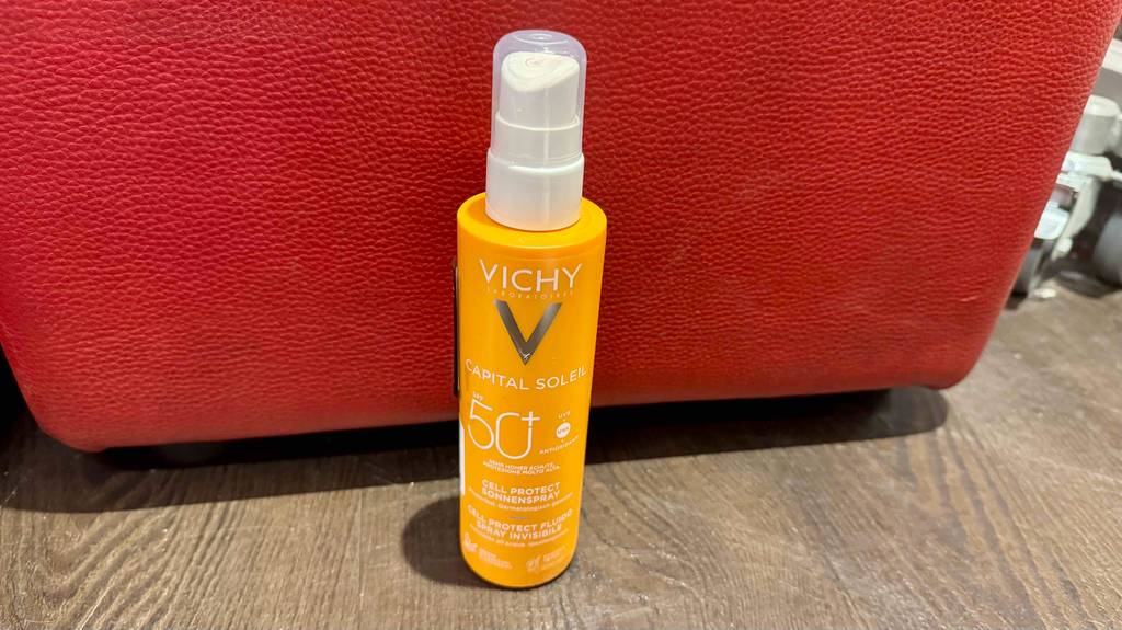 Die getestete Vichy-Sonnencreme mit SPF 50+ steht vor einem roten Gegenstand.