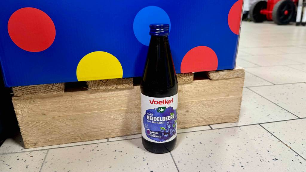 Ein getesteter Saft von Voelkel steht vor einer Palette in einem Geschäft.