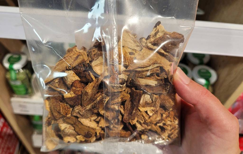 Getrocknete Steinpilze getestet: Eine Hand hält eine Packung vor ein Regal