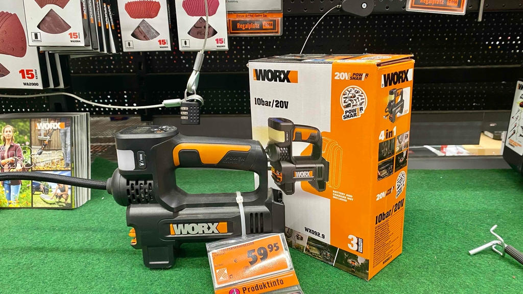 Ein getesteter Akku-Kompressor neben seiner Originalverpackung in einem Verkaufsregal.