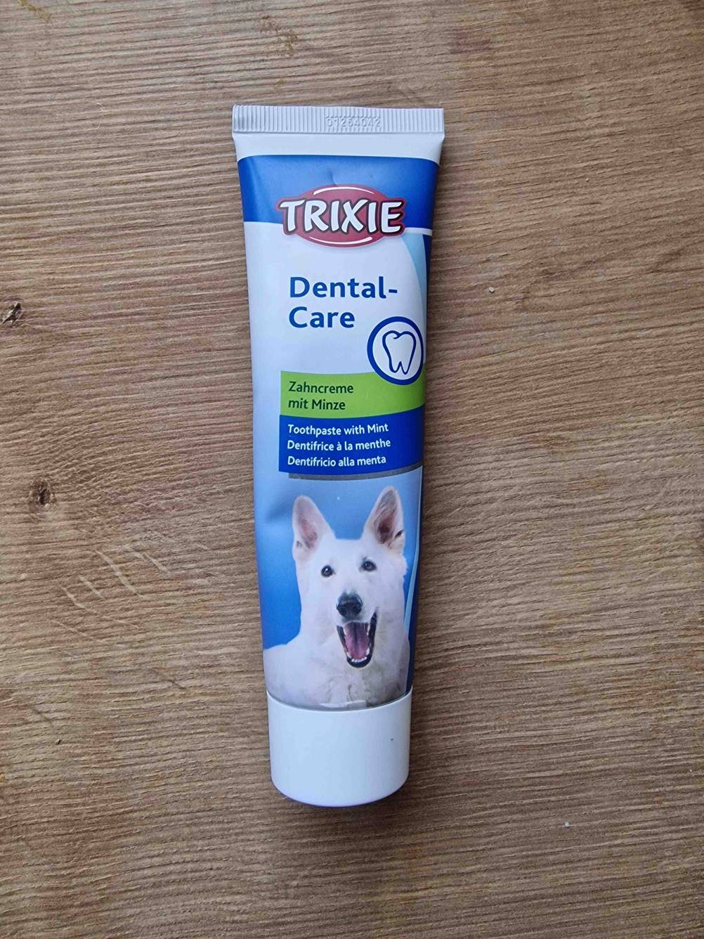 Auf einer Holzoberfläche liegt eine Tube getestete Zahnpflege (Hund)