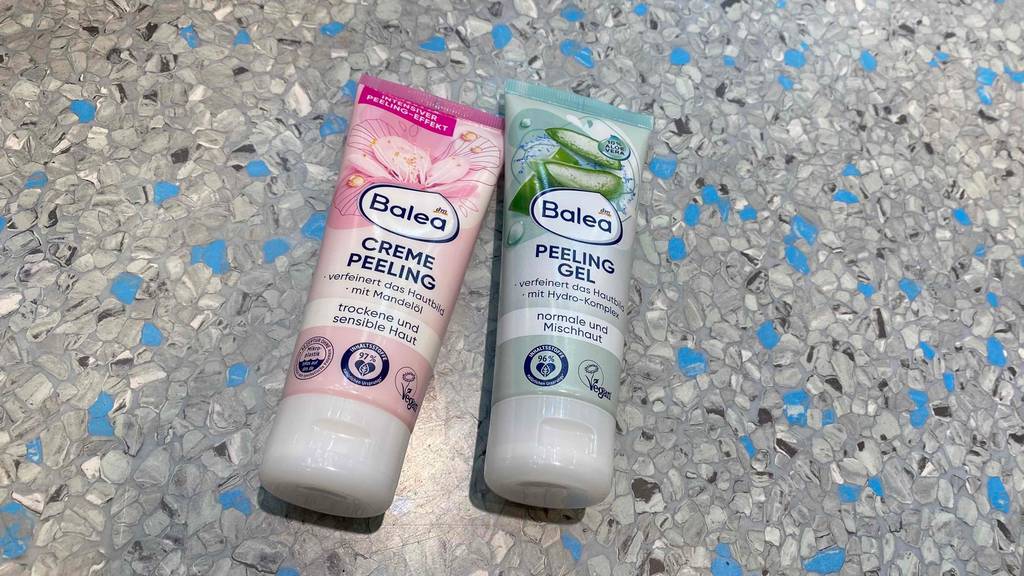 Gesichtspeeling im Test: Ein Creme-Pelling und ein Peeling-Gel liegend auf einer marmorierten Fläche.