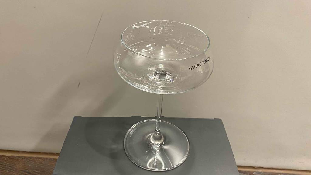 Getestetes Cocktailglas steht vor einer weißen Wand.