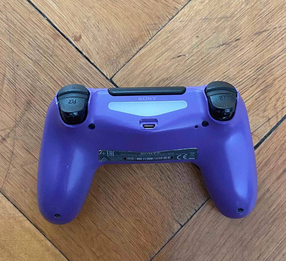 PS4-Controller im Test: ein PS4-Controller mit der Rückseite ersichtlich auf einem Boden liegend.