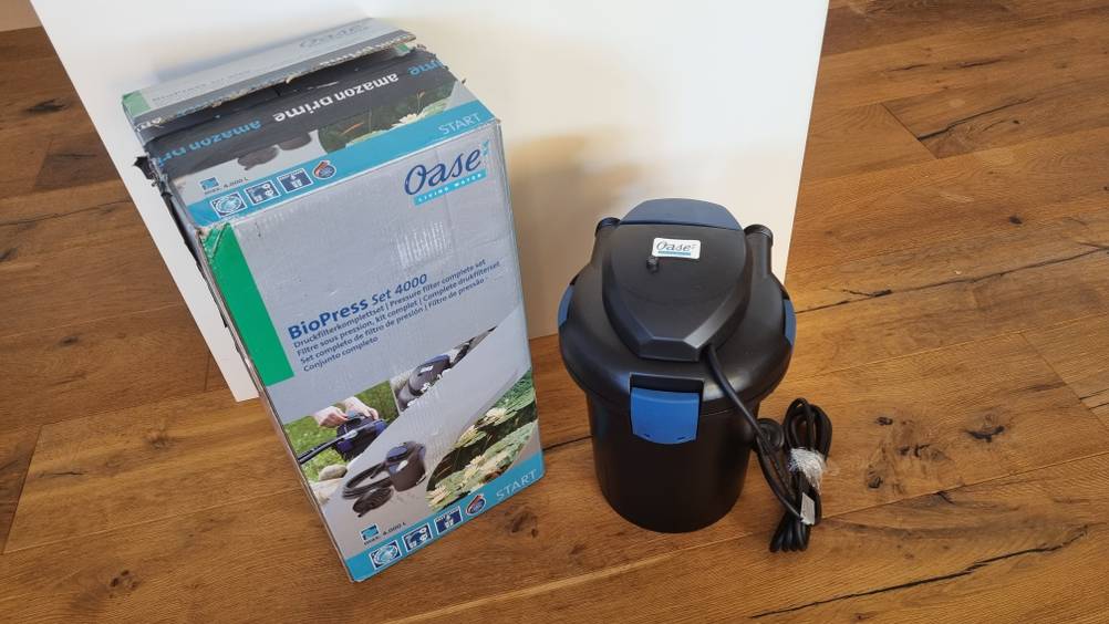 Ein schwarzer Teichfilter und dessen Verpackung, 