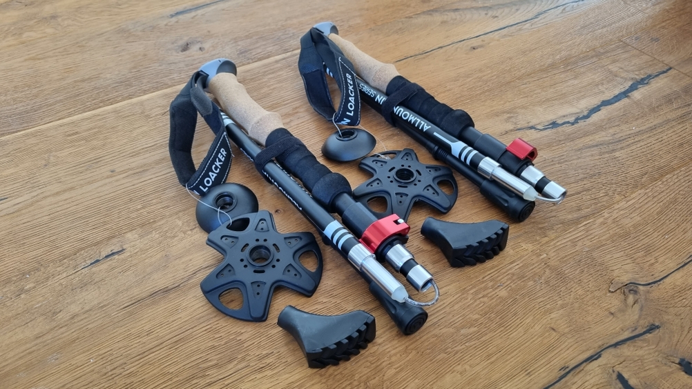 Zusammengeklappte Wanderstöcke mitsamt Zubehör. 